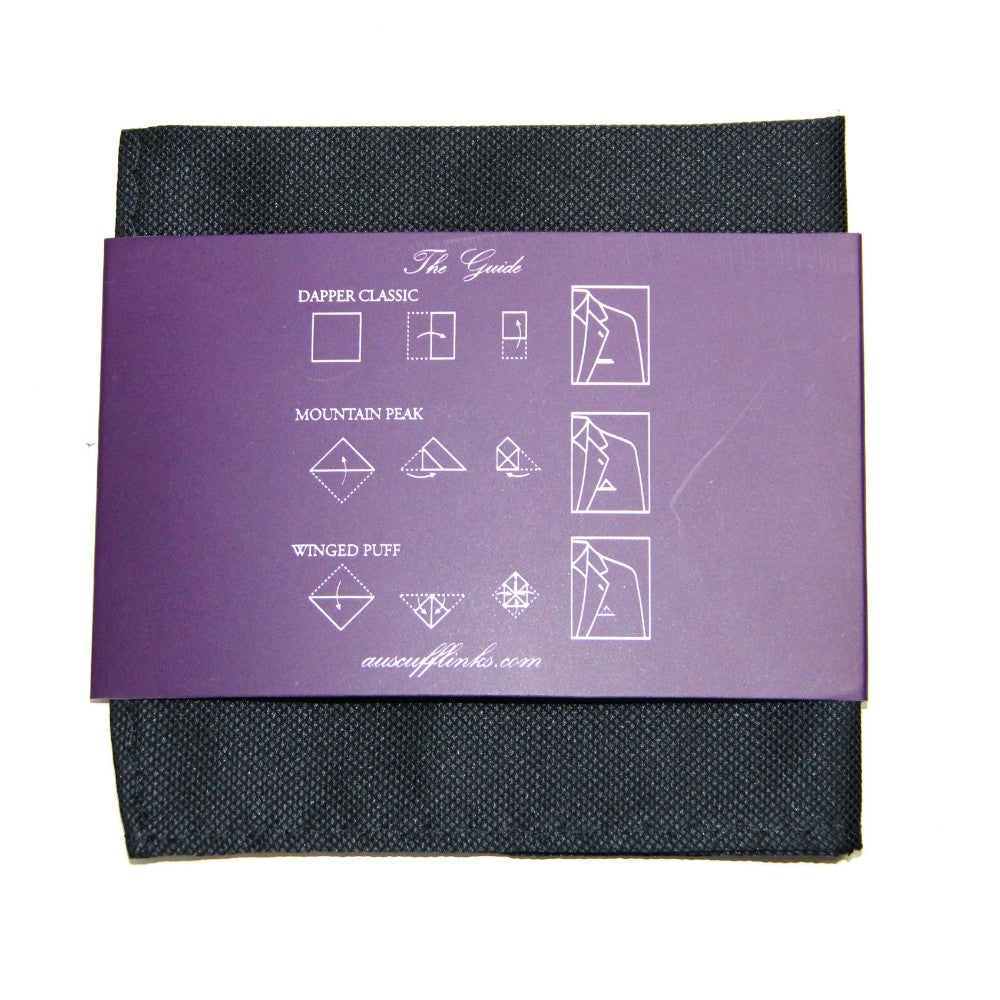 A **Black Business Tie & Pocket Square Set** with an attached purple card displaying folding instructions, including the Dapper Classic, Mountain Peak, and Winged Puff styles, ensuring an air of impeccable elegance and formality.