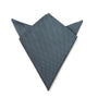 The Grey Pocket Square, folded into a geometric shape resembling a fox head with pointy ears, made from dark blue textured fabric, exudes modern elegance and adds a sophisticated touch to any ensemble.