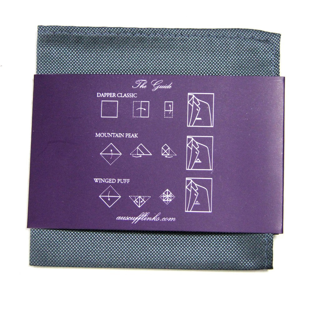 This grey pocket square, featuring a dark purple guide, exemplifies modern elegance by illustrating three folding styles: Dapper Classic, Mountain Peak, and Winged Puff with clearly labeled folds.