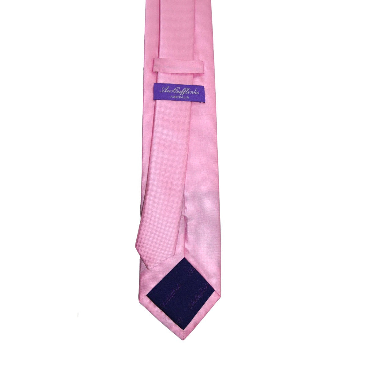The Classic Pink Skinny Tie, radiating pink elegance and adorned with a purple label featuring white text, is showcased against a plain white background.