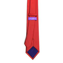 A classic red skinny tie on a white background.