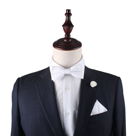 A mannequin displaying a suit with a Classic White Cotton Bow Tie in sleek sophistication.
