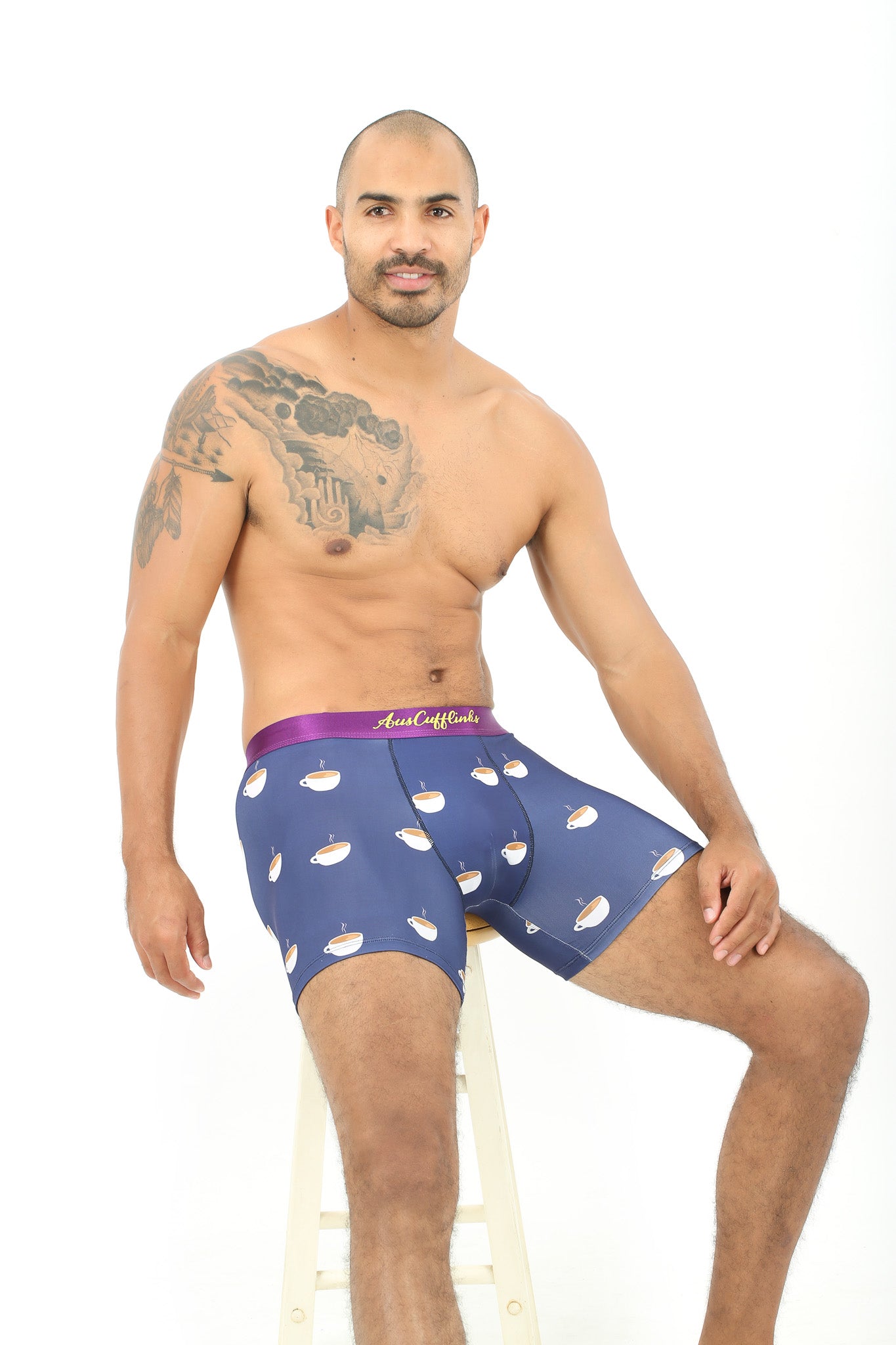 A man sitting on a stool, enjoying maximum coziness in his Coffee Patterned Underwear