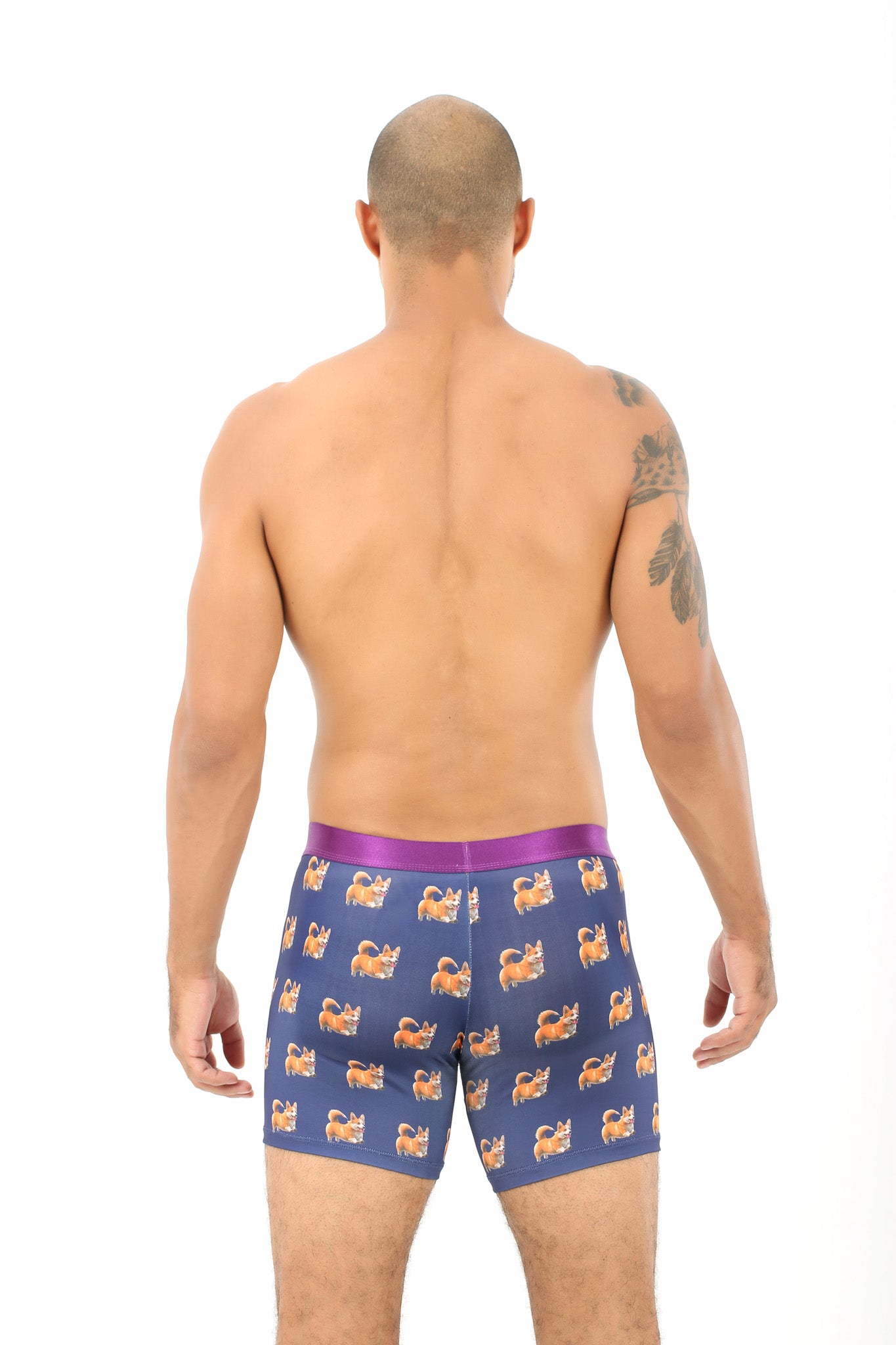A shirtless man stands with his back turned, modeling the Corgi Dog Underwear – Fun Gift for Dog Lovers, featuring blue corgi prints and a purple waistband, set against a plain white background—perfect for dog enthusiasts.