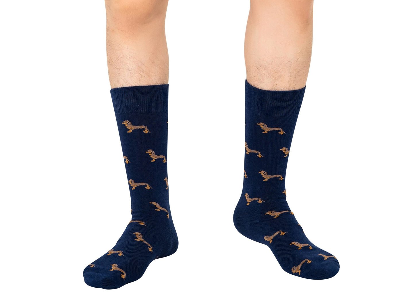 The Sausage Dog Socks, featuring a brown dachshund pattern on navy blue, are shown worn on a pair of legs against a white background.