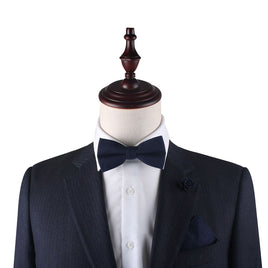 A mannequin wearing a suit and Dark Forest Navy Bow Tie with a dark allure.