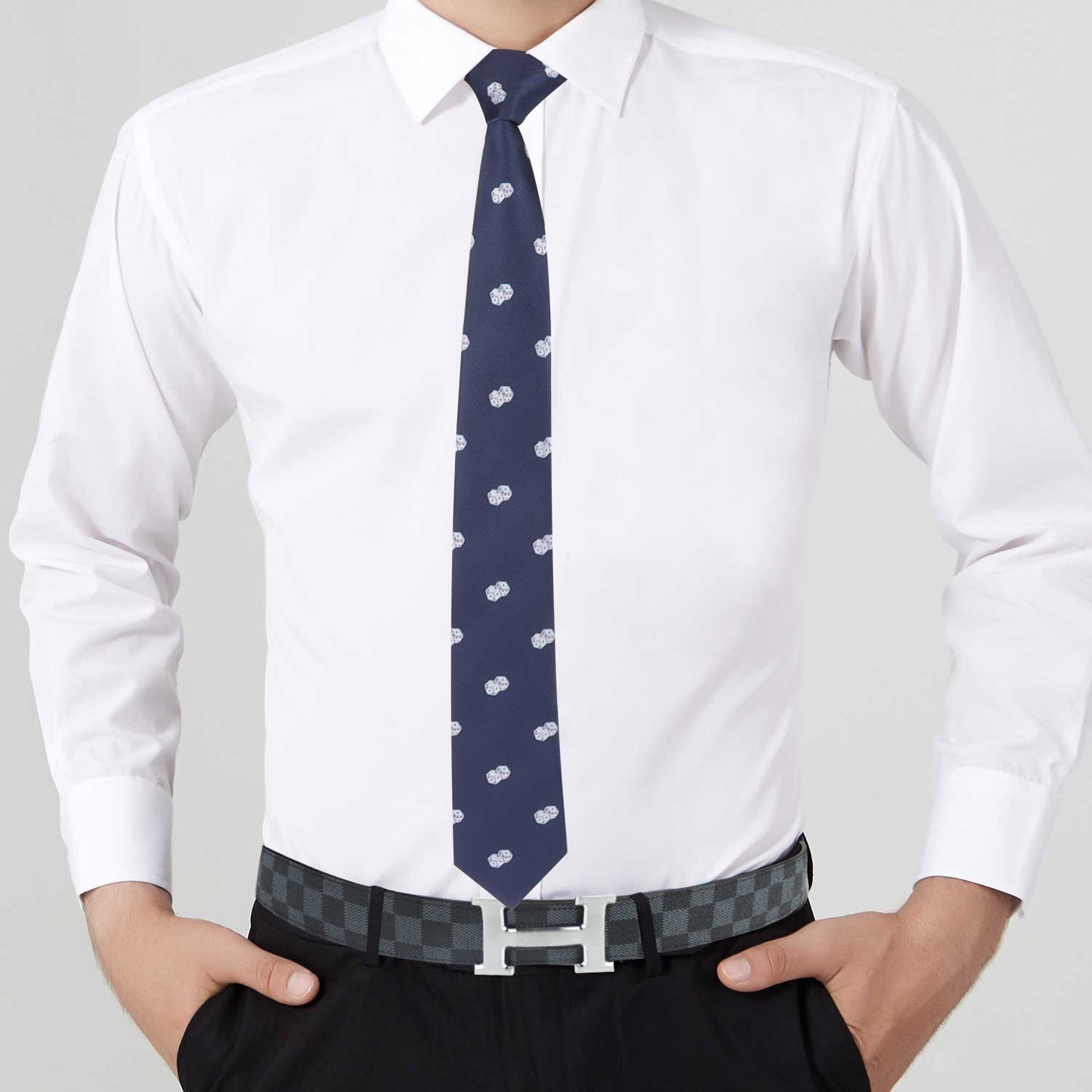 Person showcasing effortless style with a white dress shirt, black pants, and the Dice Motif Tie in navy. A checkered belt adds a touch of unique flair to this ensemble.