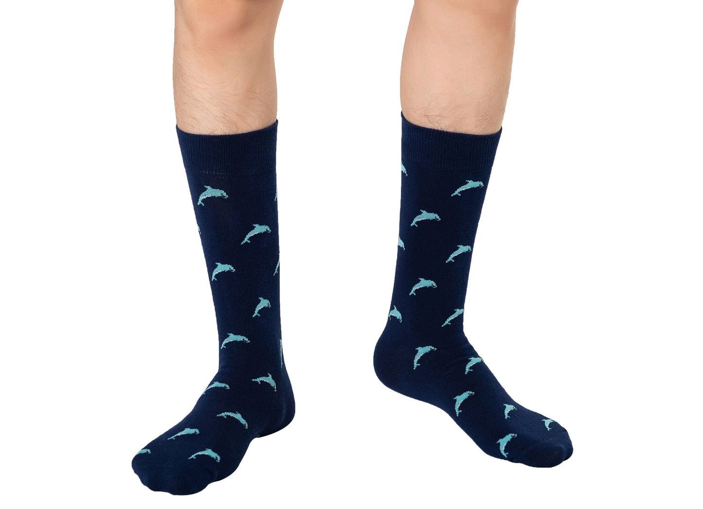 A person wearing Dolphin Socks—knee-high navy blue socks with a light blue dolphin pattern—stands on a white background.
