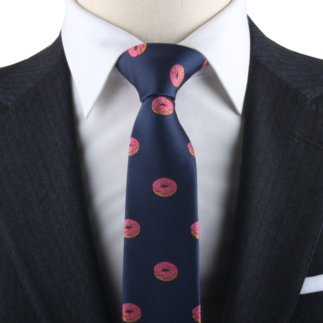 Navy tie with Donut Necktie pattern on a mannequin wearing a white shirt and dark suit jacket, adding delectable style.