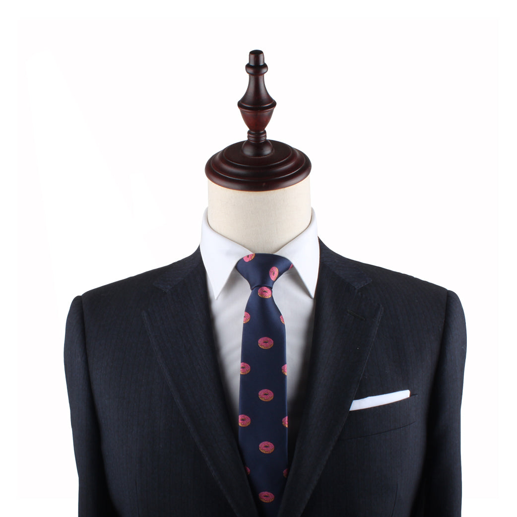 Mannequin displaying engaging style with navy suit, Donut Thin Tie, and pocket square.
