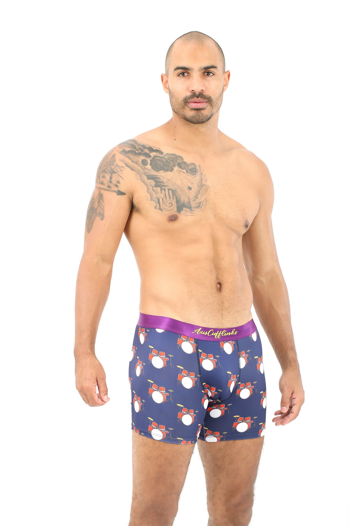 A man with a tattoo on his shoulder wears a pair of Drums Underwear boxer briefs, featuring vibrant drum set patterns that move in perfect rhythm, providing ultimate comfort.