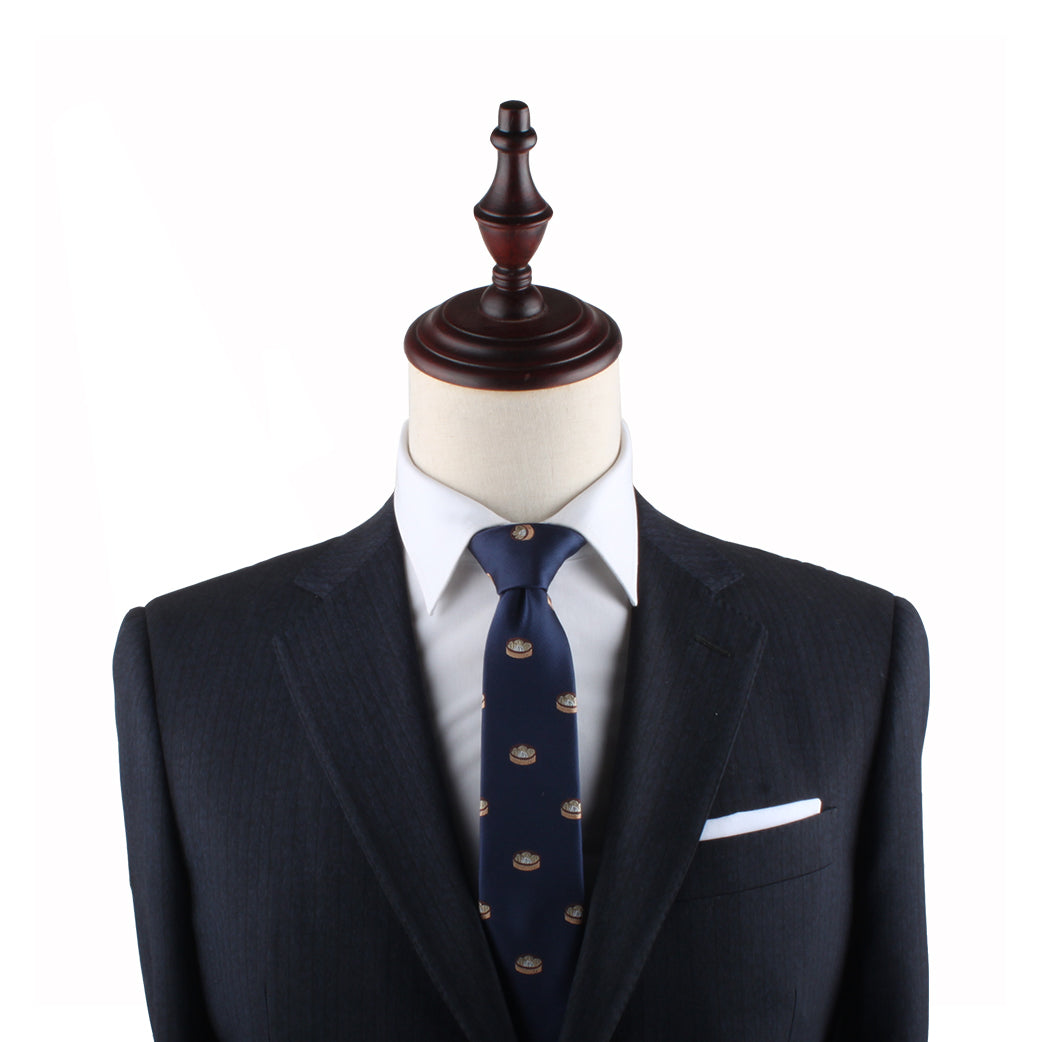 A headless mannequin dressed in a dark suit with a white shirt and a Dumplings Slim Tie, exuding timeless elegance.