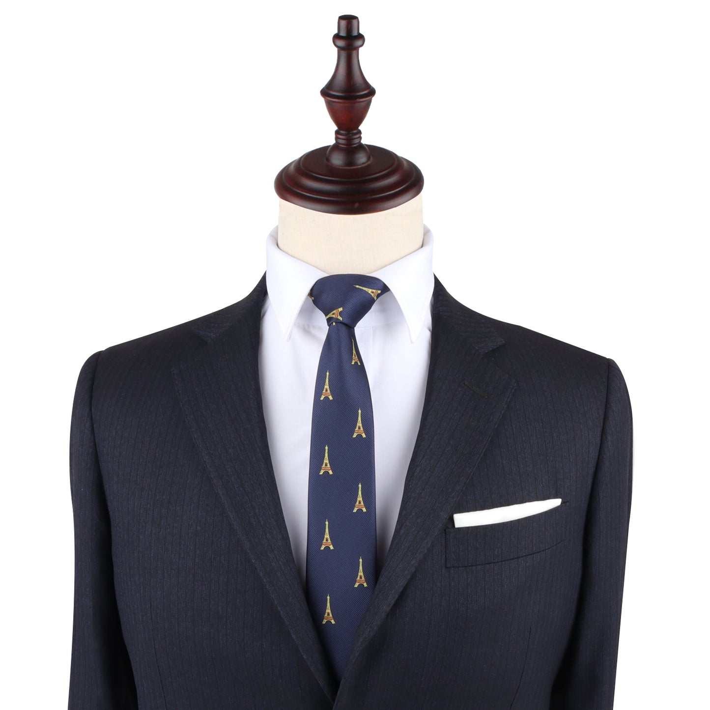 A mannequin dressed in a dark suit with a white dress shirt and an Eiffel Tower Slim Tie exudes Parisian elegance. A white pocket square is neatly tucked into the jacket's breast pocket, completing the sophisticated woven look.