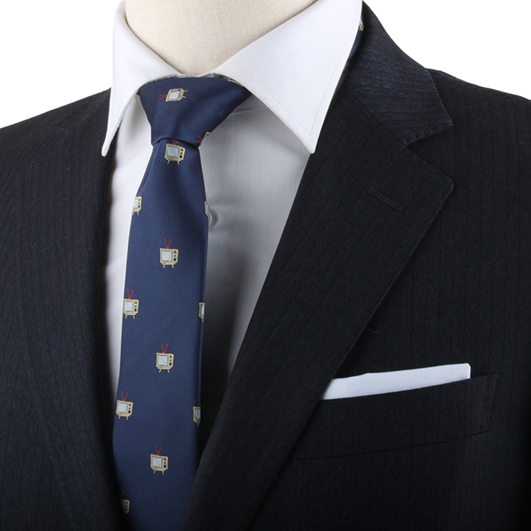 A close-up of a mannequin dressed in a black suit and white shirt exuding elegance, with the Film and TV Tie featuring small TV graphics and a pocket square.