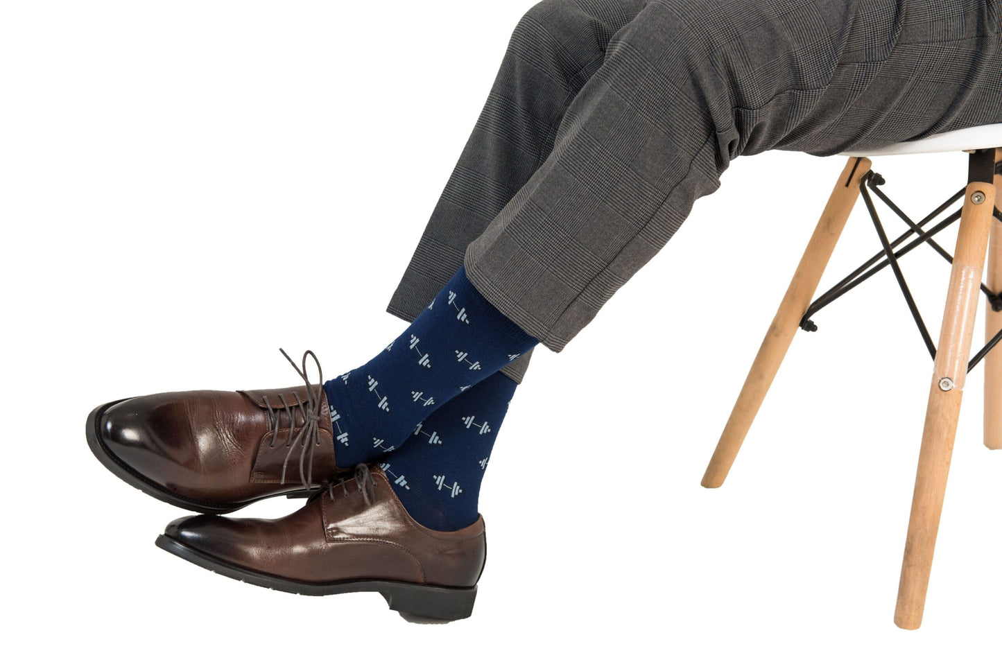 A man sitting on a chair wearing a pair of brown shoes and Gym Socks.