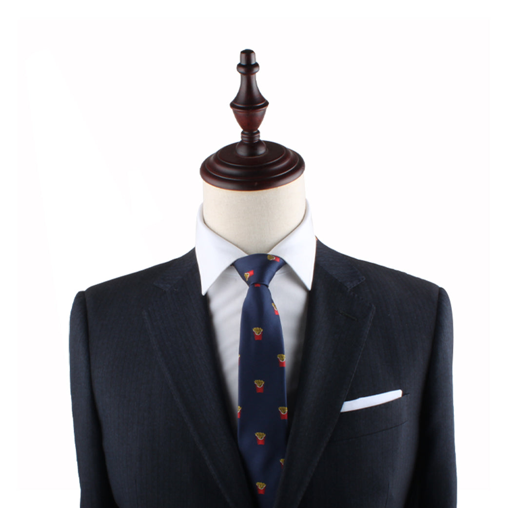 A mannequin dressed in a dark suit with a white dress shirt, the Fries Slim Tie featuring red and yellow accents, and a white pocket square exudes modern sophistication.