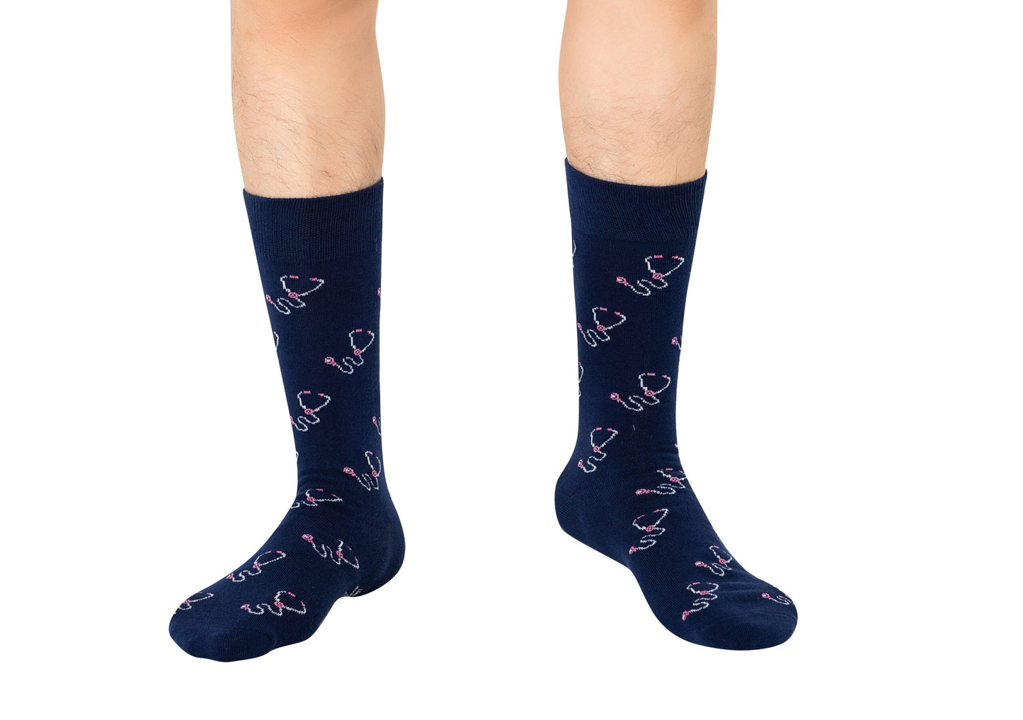 A person wearing Stethoscope Socks in navy blue with a pink and white pattern, standing on a white background.