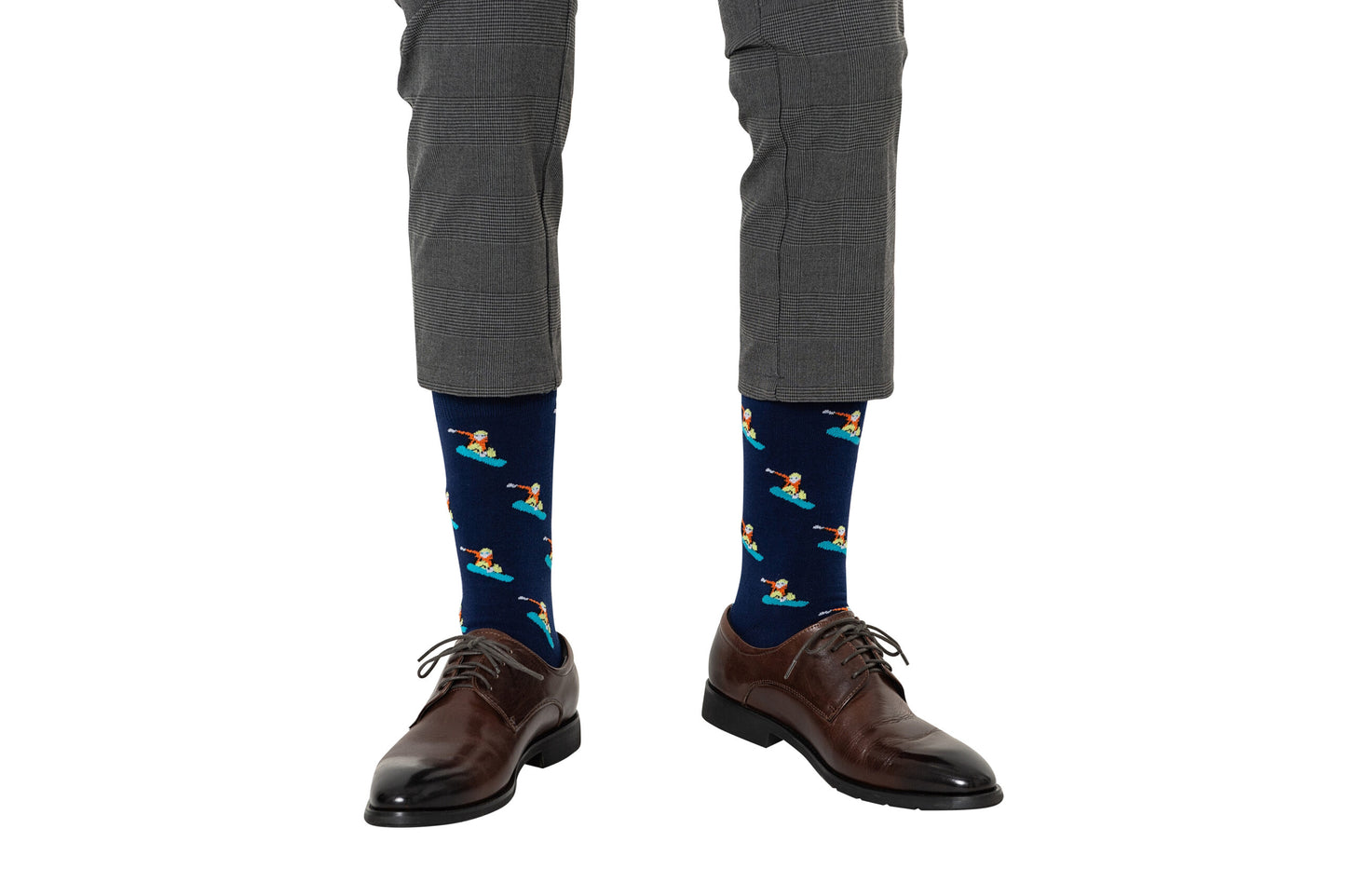 A person wearing gray plaid pants, brown dress shoes, and navy blue Snowboarder Socks featuring a cartoon duck pattern.