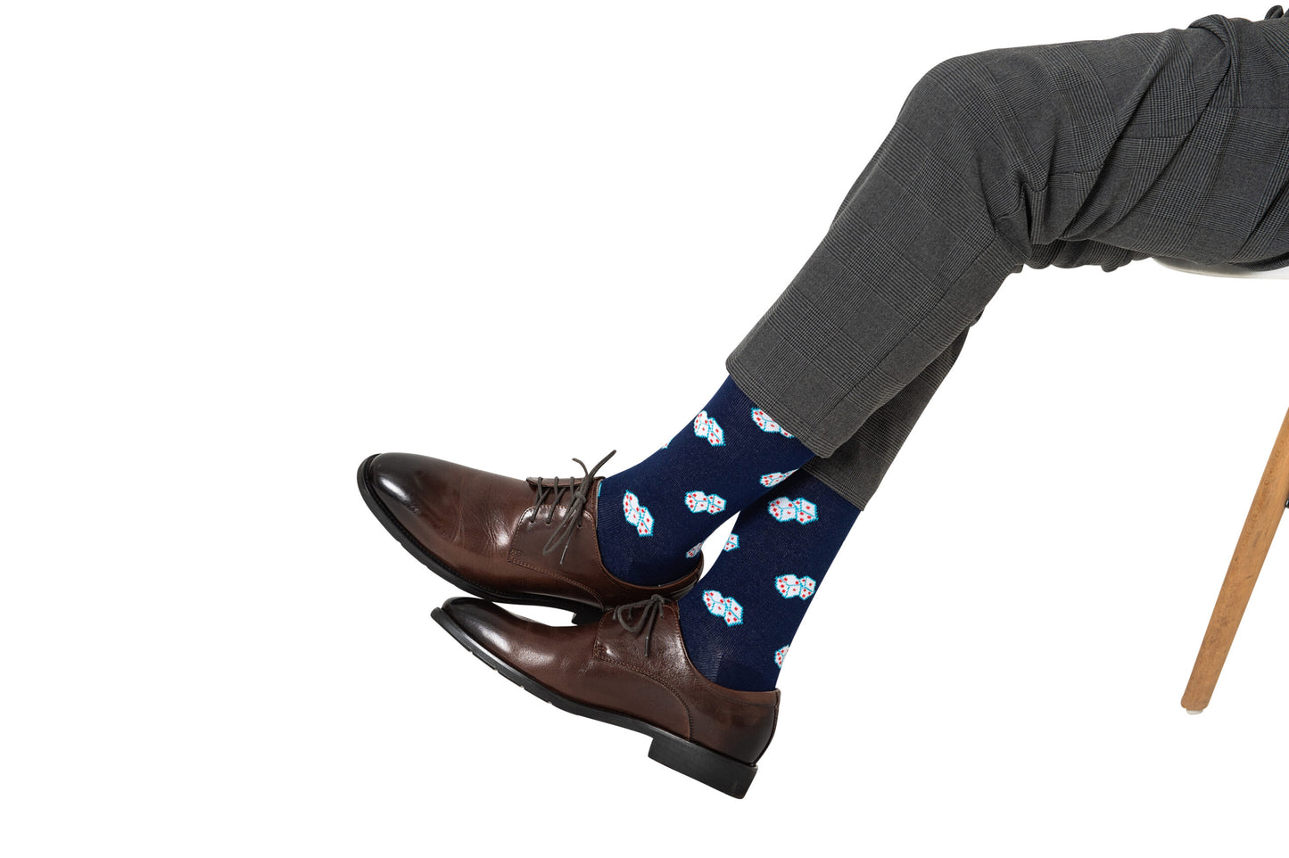 A person in gray dress pants and brown leather shoes wears Dice Socks – Lucky Gift for Game Lovers, featuring a navy blue, white, and red dice pattern—ideal style for board gamers or casino fans.