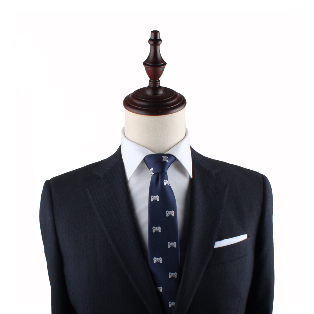 A dark grey suit with a white dress shirt and a Game Controller Slim Tie is displayed on a mannequin with a wooden finial, perfectly capturing the style sought by trendsetters.