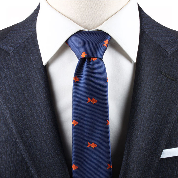 Close-up of a person dressed in a dark suit and white shirt, wearing a Goldfish Necktie featuring an orange goldfish design.