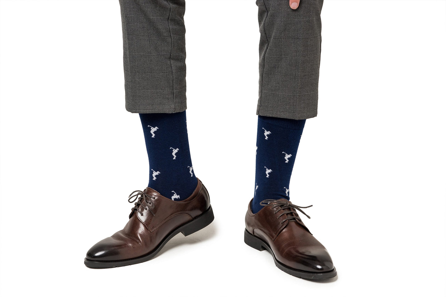 A man wearing a pair of brown shoes and Golf Swing Socks.