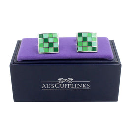 A pair of Coral Green Cufflinks in a purple box with a polished finish.