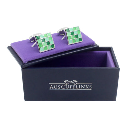 A pair of Coral Green Cufflinks in a purple box.