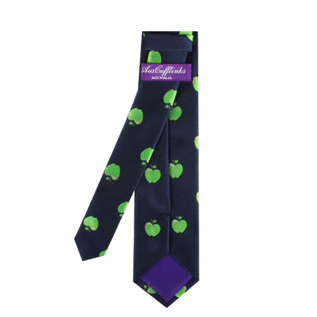 A navy blue Green Apple Tie with a pattern of green apples, exuding natural freshness, is shown neatly folded. The inner lining is purple, and a tag reads "AustCufflinks," adding a touch of modern style to this distinctive accessory.