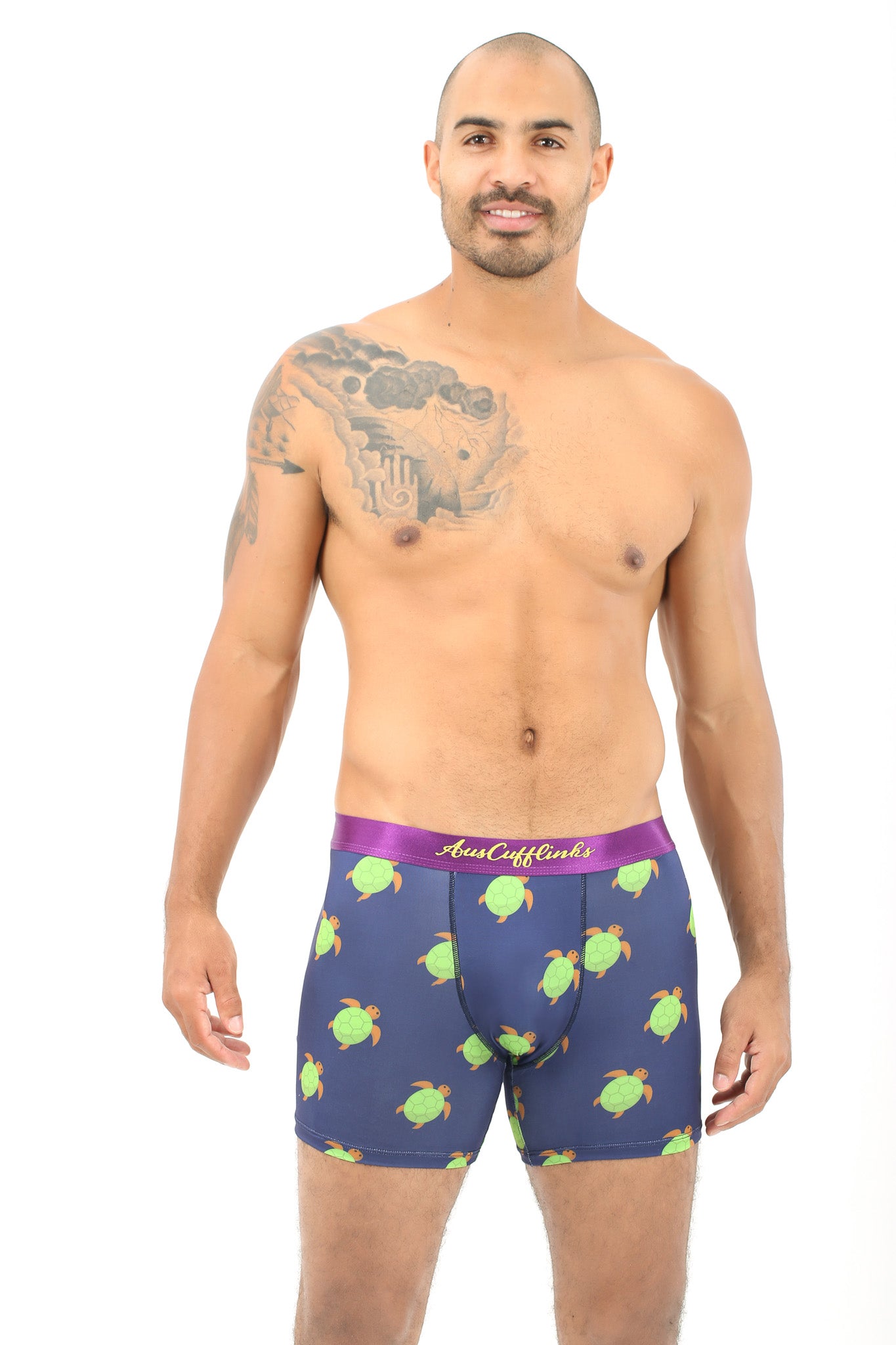 Wearing the Green Turtle Boxer, a man with a tattoo on his upper arm radiates slow-paced snugness, confidently embracing a subtle triumph of comfort and style.