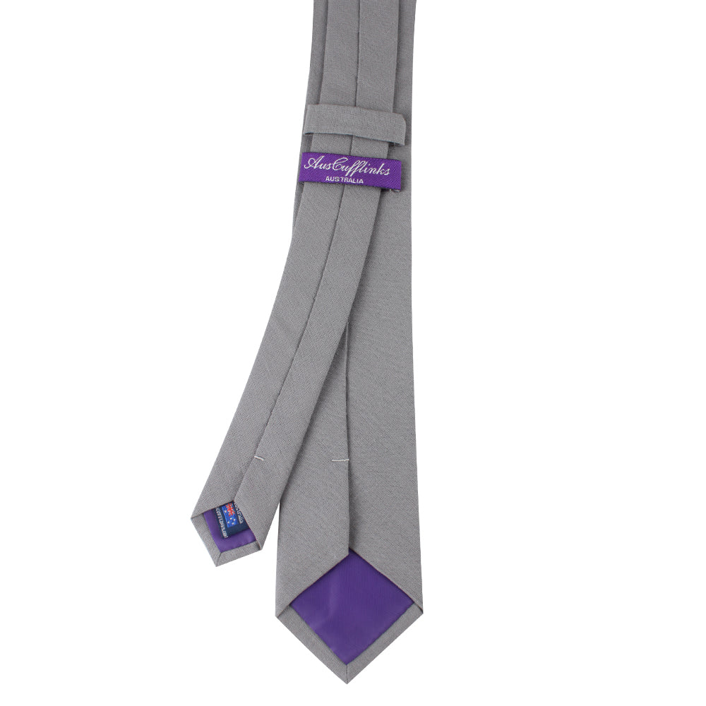 A Brushed Grey Skinny Cotton Tie and Purple Necktie on a White Background.