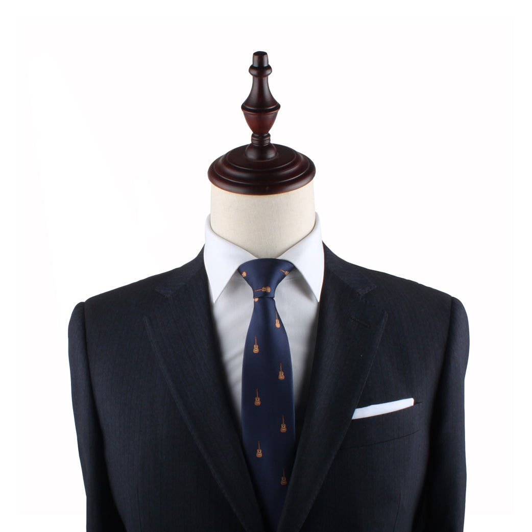 Mannequin torso dressed in a navy blue suit with a Guitar Thin Tie and a white pocket square, set against a white background.