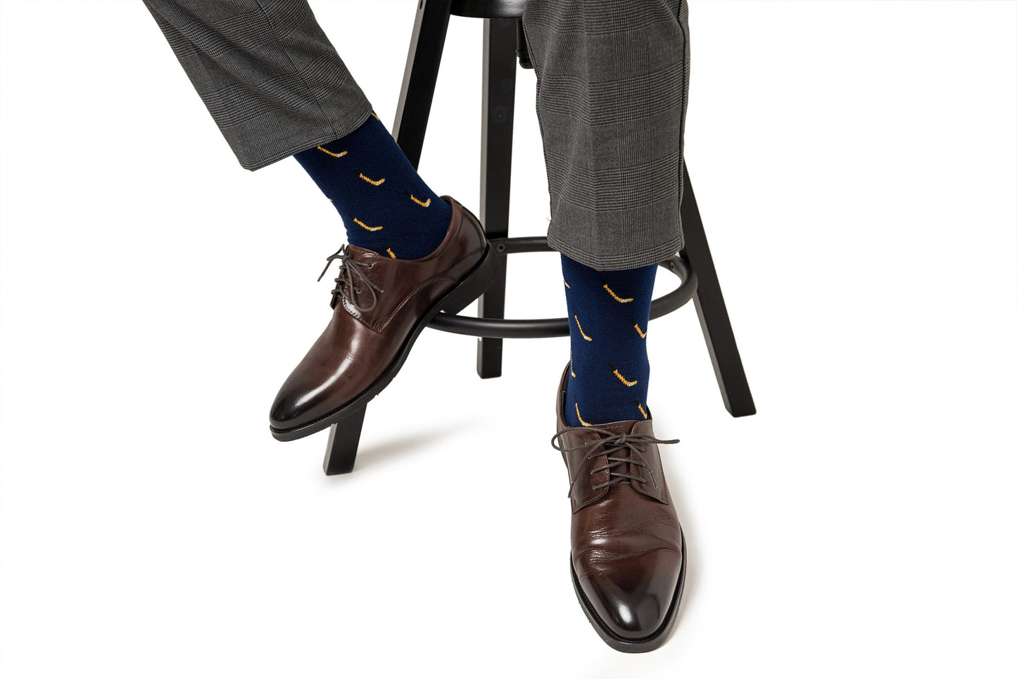 A man sitting on a stool wearing a pair of Ice Hockey Socks.