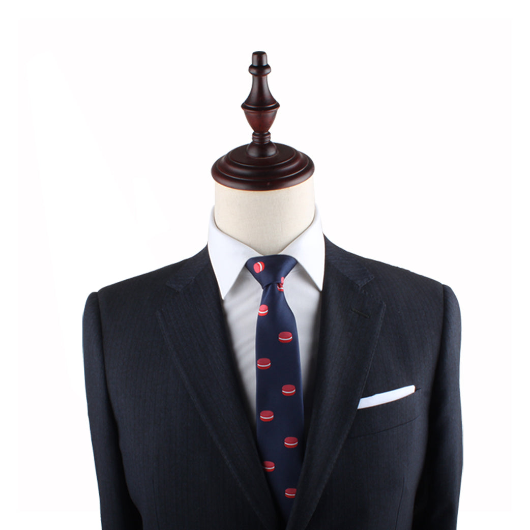 A headless mannequin is dressed in a dark suit, white shirt, Macaron Skinny Tie with red patterns, and a white pocket square.