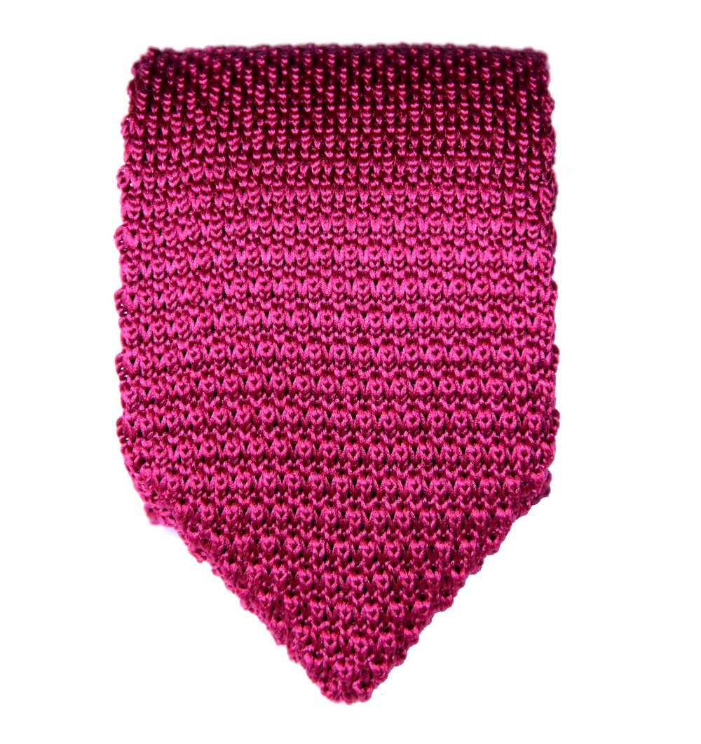A burgundy red knit tie on a white background, adding a touch of sophistication.