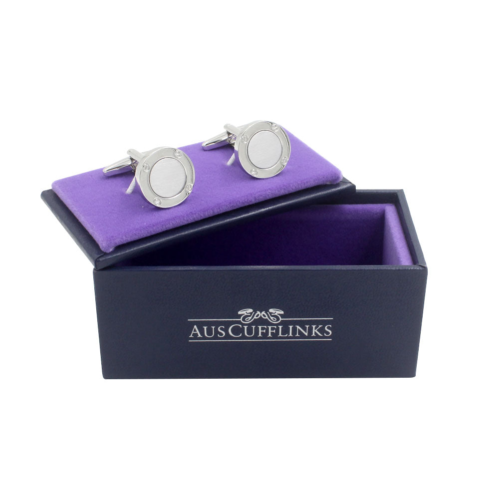 Inner Circle Silver Cufflinks, featuring a polished circular design, rest elegantly on a purple cushion inside a black box labeled "Auscufflinks.
