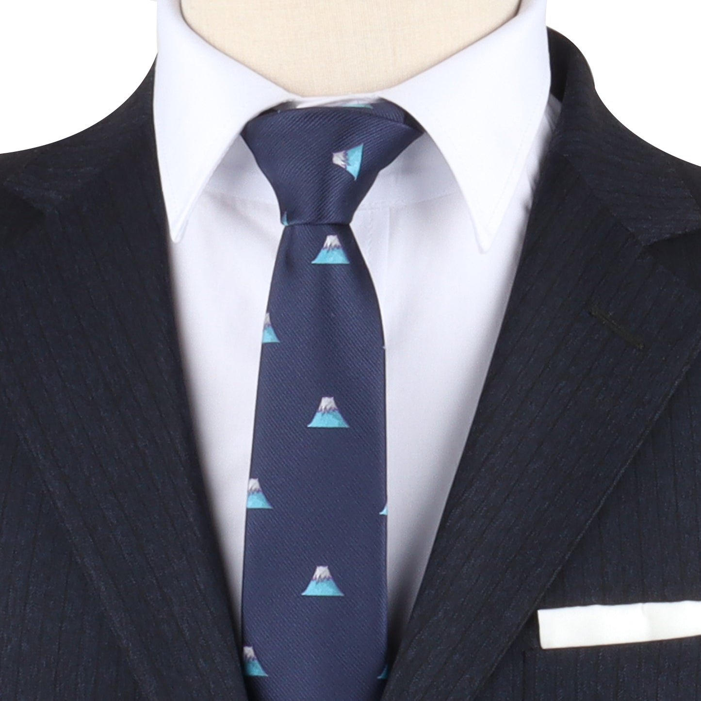 Close-up of a person wearing a dark suit with a white shirt and the Mountain Range Tie, which features an elegant mountain pattern that captures the beauty of nature. A white pocket square stylishly complements the suit's breast pocket.