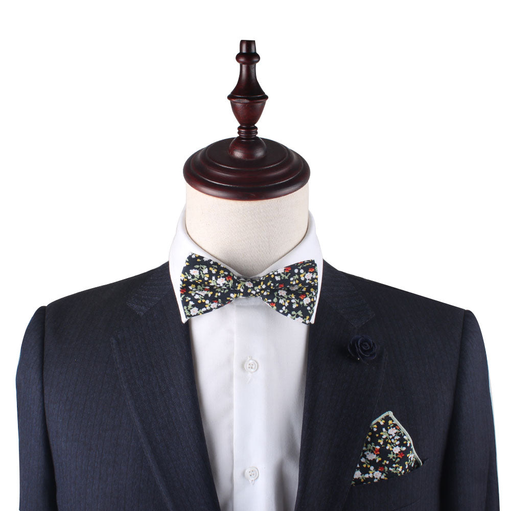 A mannequin in a dark suit and white shirt showcases a stylish look with a vibrant floral bow tie, perfectly complemented by the Multi Floral Pocket Square.