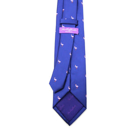 The Pink Flamingo Navy Skinny Tie features a pattern of small pink flamingos and a pink label stitched with stylized text, effortlessly blending playful charm with standout elegance.