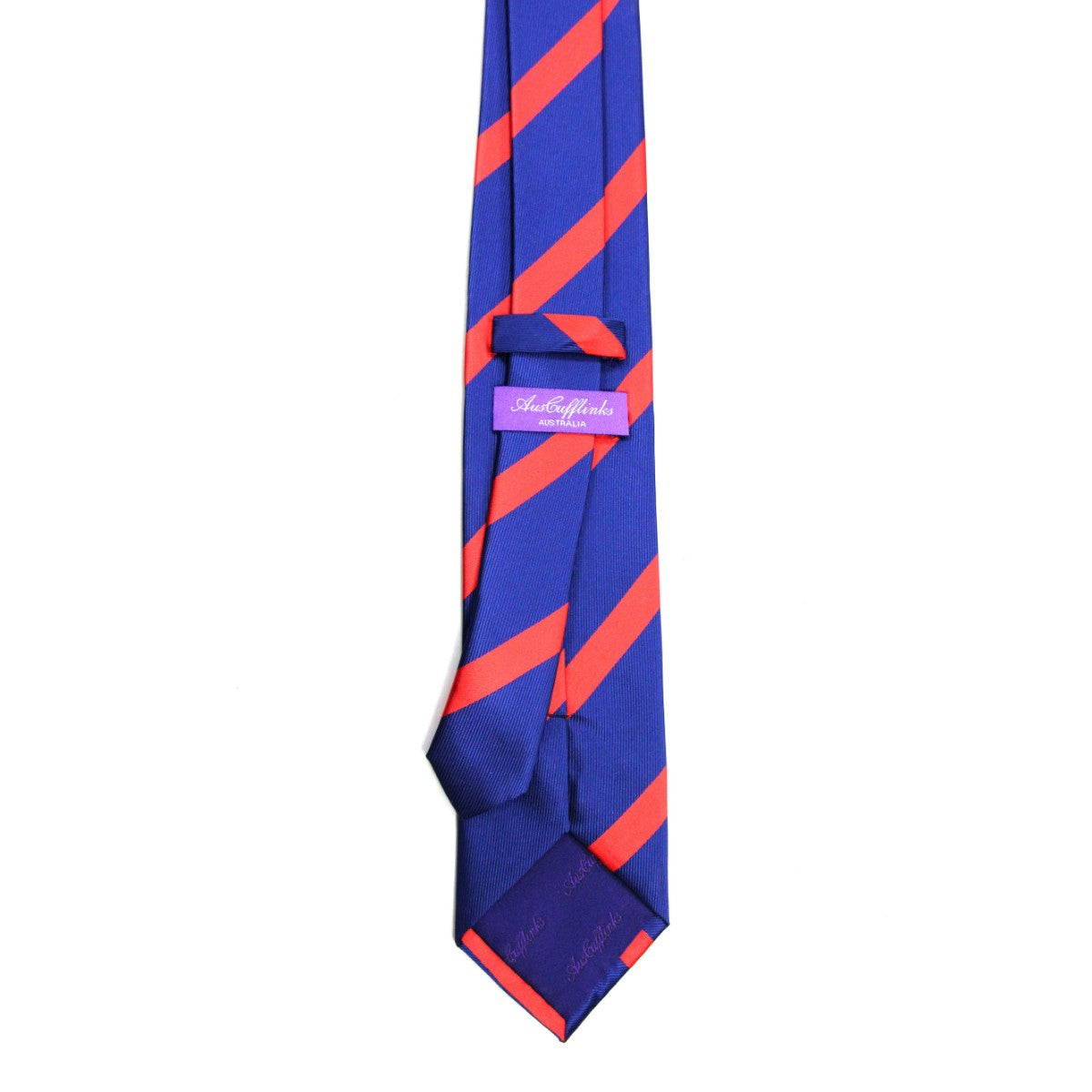 The Navy Reddish Pink Stripe Skinny Tie is a slim blue necktie for men with diagonal reddish pink stripes, a purple label with text on the back, and extra text on the inner tip.