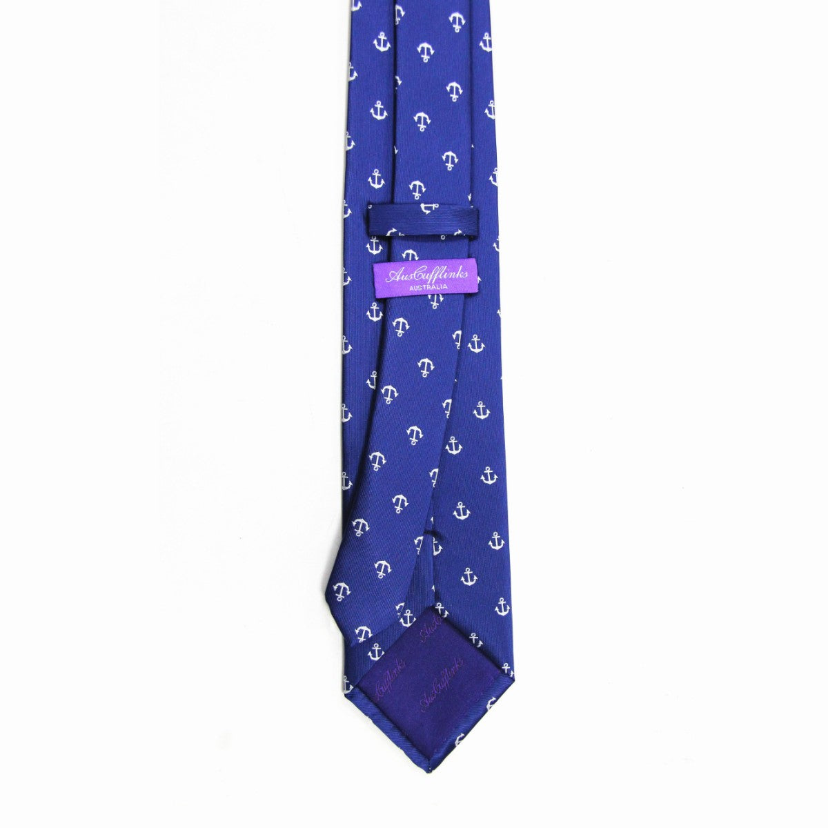 Introducing the Navy Anchor Business Tie & Pocket Square Set: a blue tie with white anchors, perfect for formal attire, complemented by a pink label on the back adding nautical flair to your business wear.