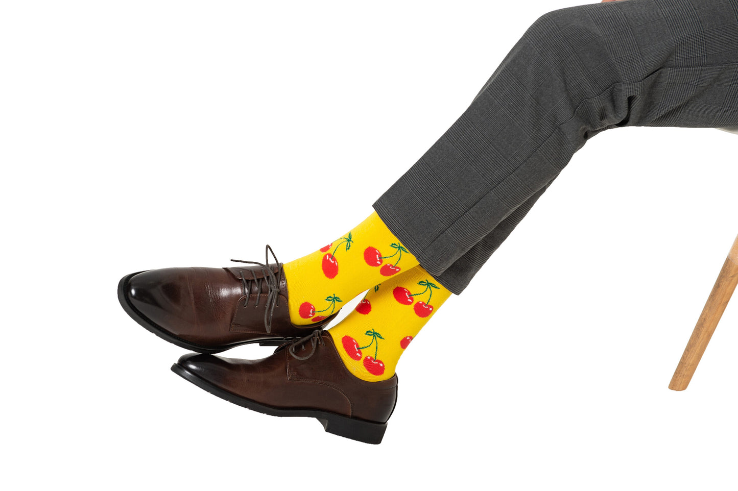 A man sitting on a chair wearing a pair of Cherry Socks.