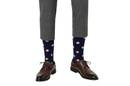 A product description for a person clad in gray trousers, featuring citrusy comfort blue Orange Socks adorned with an orange pattern from heel to toe, and stylish brown dress shoes.