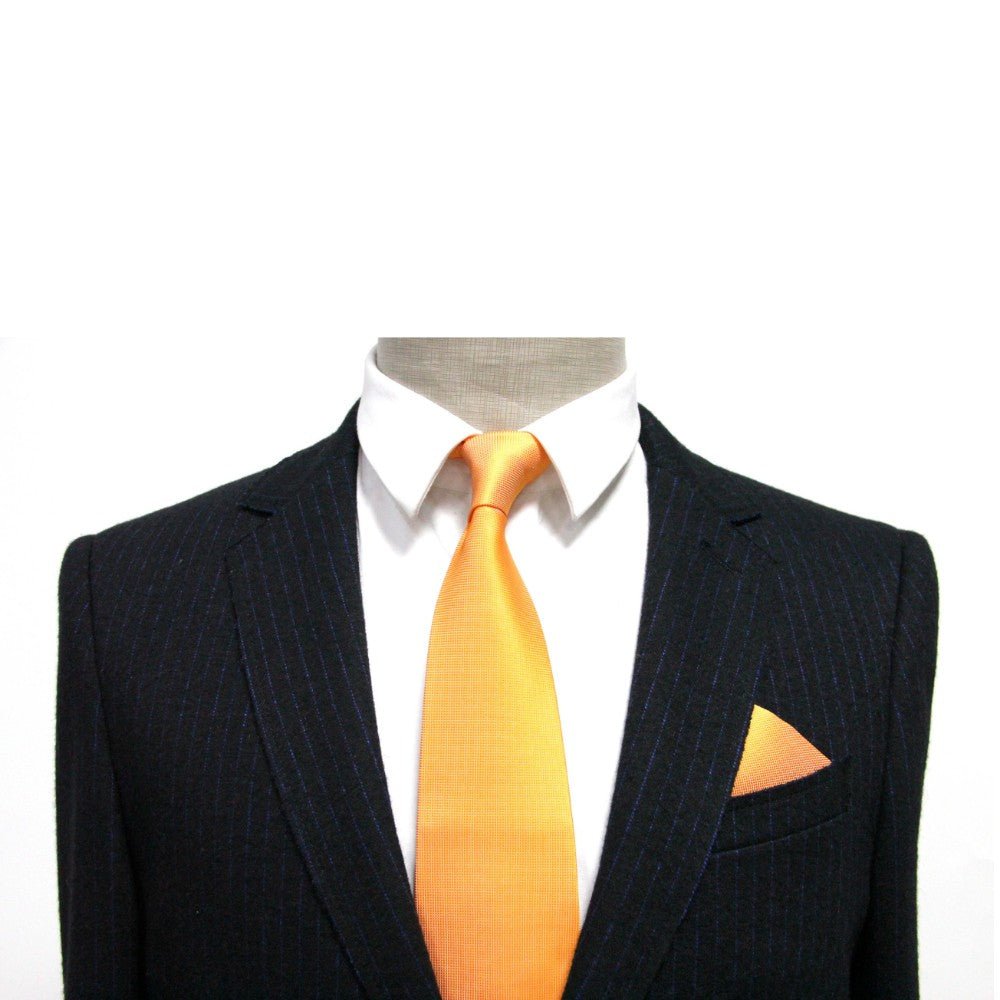 A black pinstripe suit with a white shirt and orange tie evokes elegance, enhanced by the vibrant Orange Pocket Square neatly tucked in the jacket pocket.