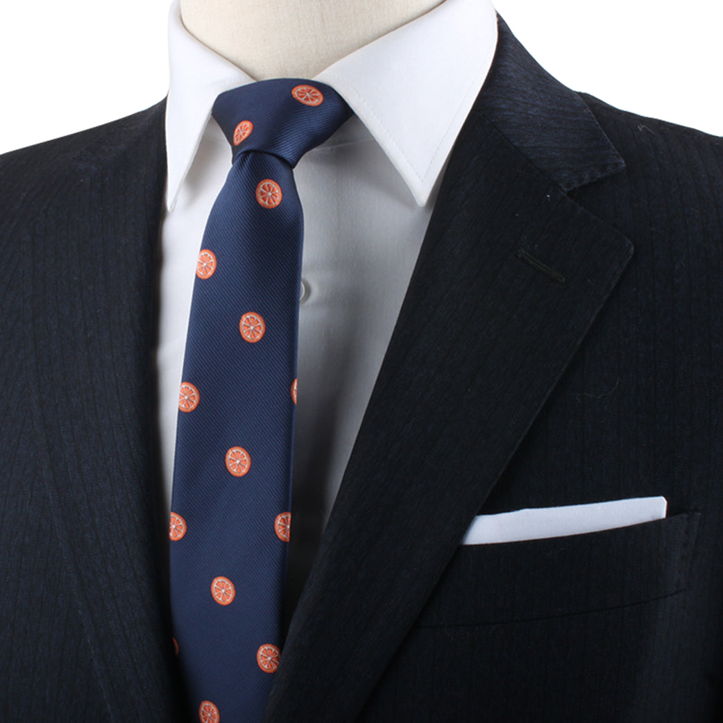 A person wearing a dark suit, white dress shirt, and an Orange Skinny Tie.