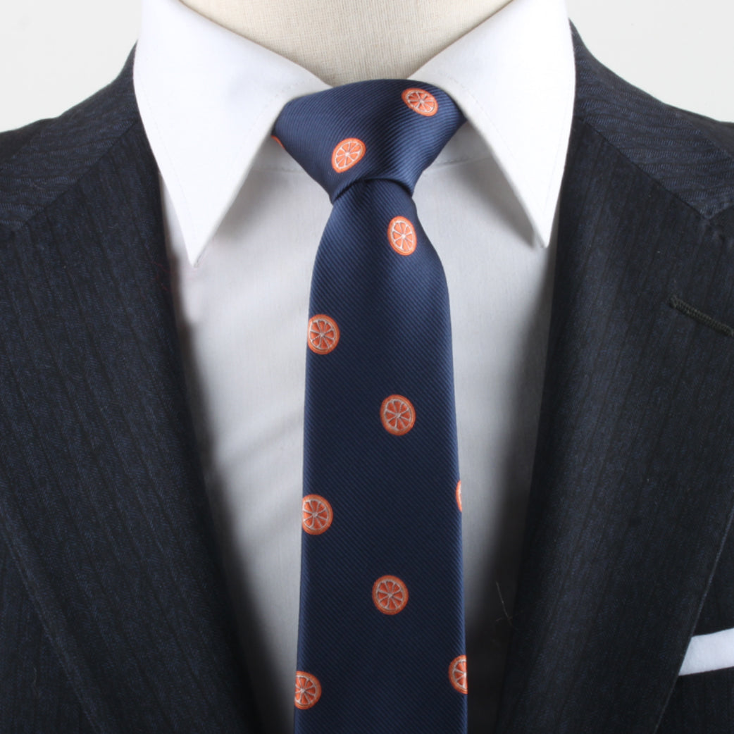 Close-up of a person wearing a dark pinstripe suit, white dress shirt, and an Orange Necktie that adds a burst of charm.