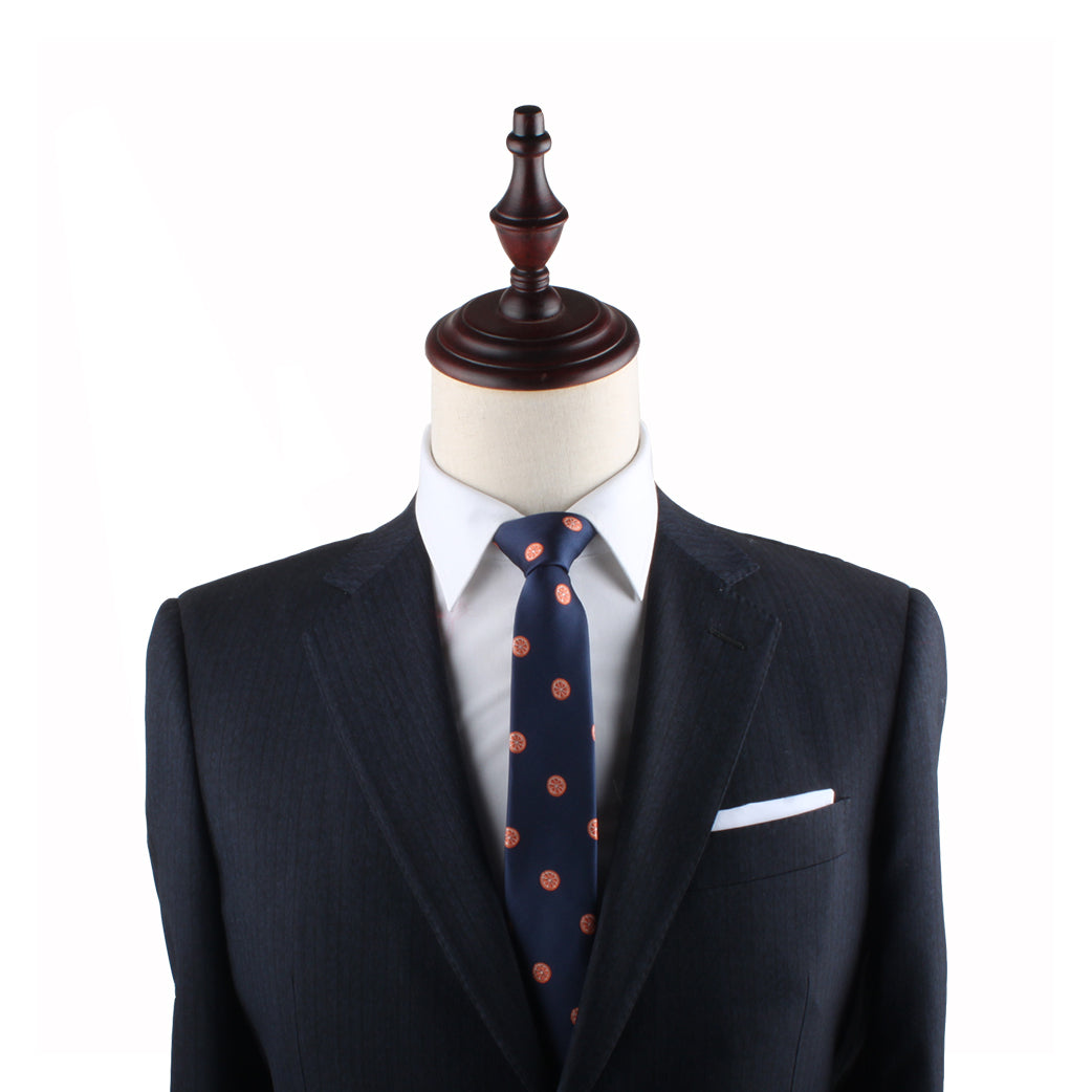 A mannequin dressed in a dark formal suit, white dress shirt, and an Orange Slim Tie exudes charm.