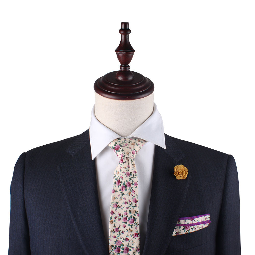 Mannequin wearing a dark suit, white shirt, Pastel Pink Rose Floral Skinny Cotton Tie, and pocket square, adorned with a yellow flower lapel pin, showcasing streamlined charm.