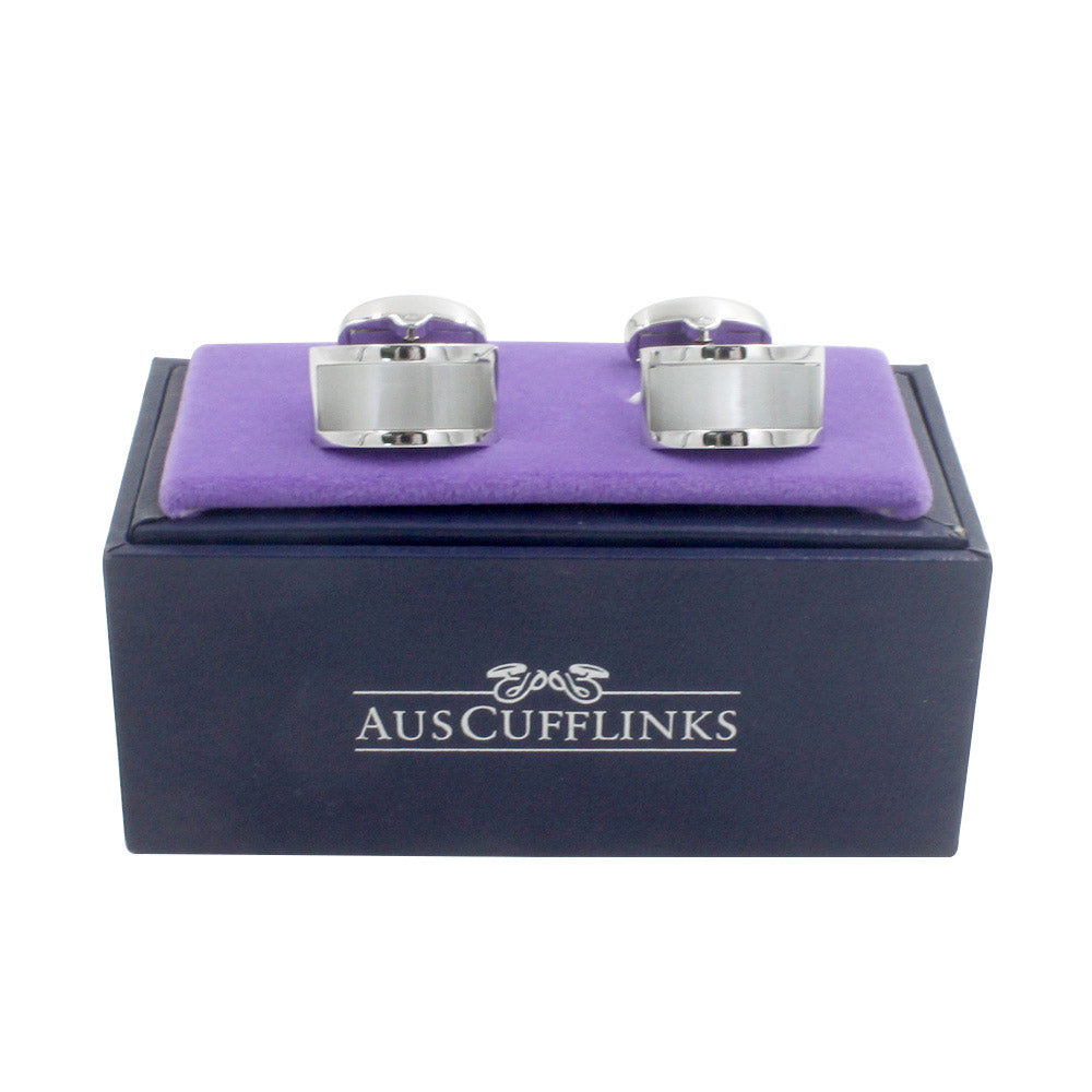 A pair of Pearl White Cufflinks, exuding lustrous charm, displayed on a purple cushion atop a blue rectangular box labeled "AUSCUFFLINKS.