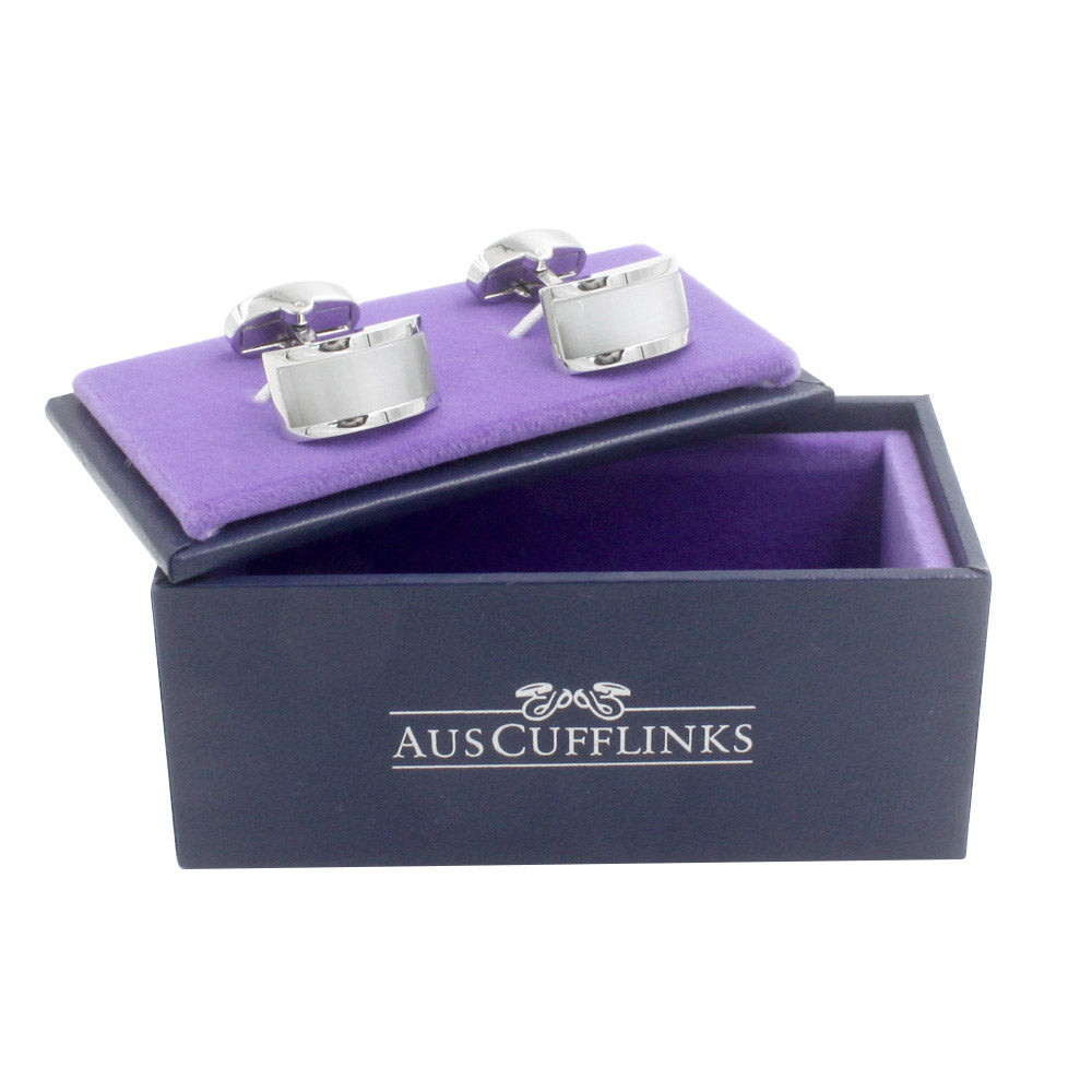 A pair of Pearl White Cufflinks radiating a lustrous charm, displayed on a purple velvet-lined box with the brand name "Aus Cufflinks" printed on the side. Perfect for the classic man.